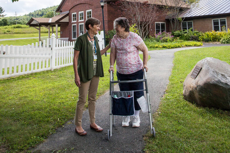 Physical therapist talking with a patient using a walker