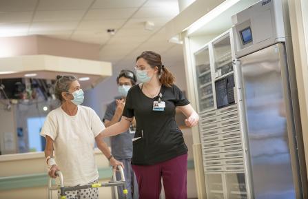 Photo of women walking down a hallway with helper.