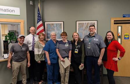 Sandy Connolly stands in group photo with other employees, as Employee of the Month