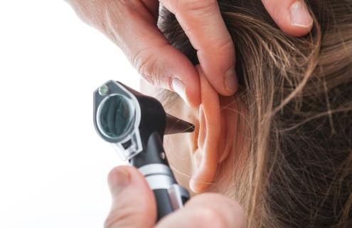 Medical provider examining a patient's ear