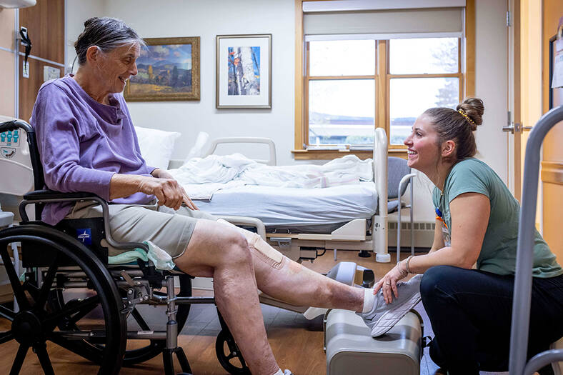 Physical therapist working with patient in wheelchair